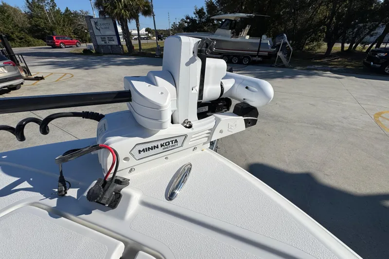 Slide: The Image of 2026 Caymas 26 HB boat with Minn Kota trolling motor in a marina setting. - 21