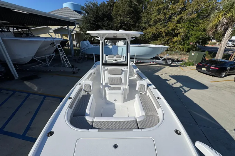 Slide: The Image of 2026 Caymas 26 HB boat in a marina, showcasing sleek design and spacious deck. - 23