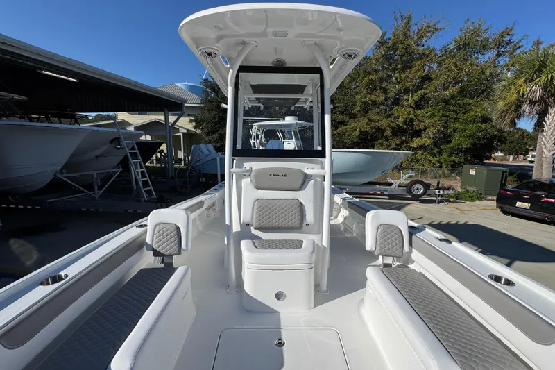 Slide: The Image of 2026 Caymas 26 HB boat interior with seating and console, docked outdoors. - 24