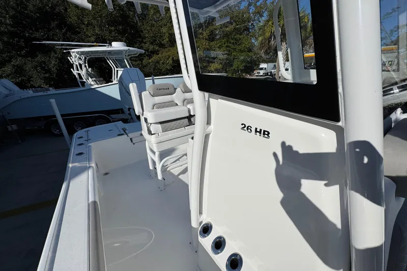 Slide: The Image of 2026 Caymas 26 HB boat with seating and console, parked outdoors. - 26