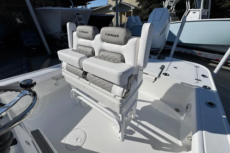 Slide: The Image of 2026 Caymas 26 HB boat interior with cushioned seating and steering wheel. - 29