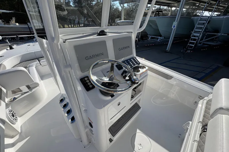 Slide: The Image of 2026 Caymas 26 HB boat cockpit with Garmin navigation system and sleek steering wheel. - 32