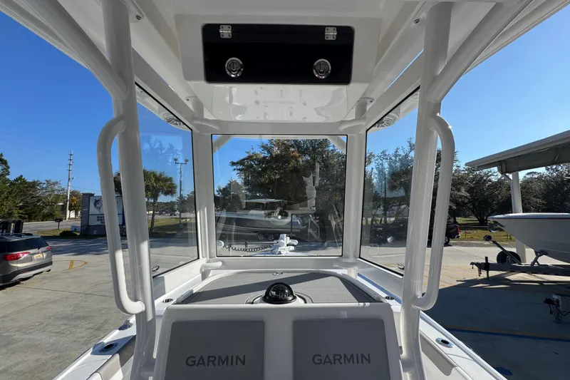 Slide: The Image of 2026 Caymas 26 HB boat interior with Garmin navigation, parked outdoors under clear blue sky. - 34