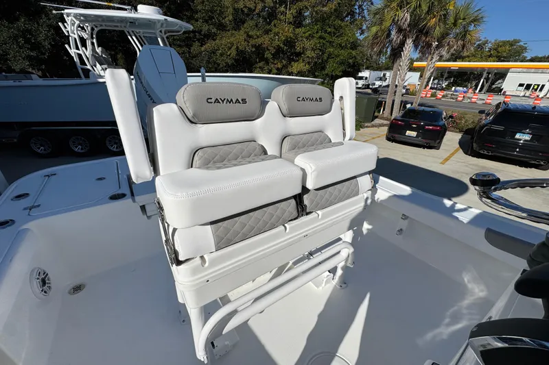 Slide: The Image of 2026 Caymas 26 HB boat with cushioned seating, parked outdoors. - 36