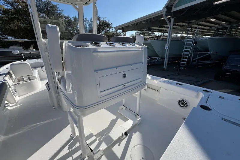 Slide: The Image of 2026 Caymas 26 HB boat interior with console and seating, docked under a canopy. - 37