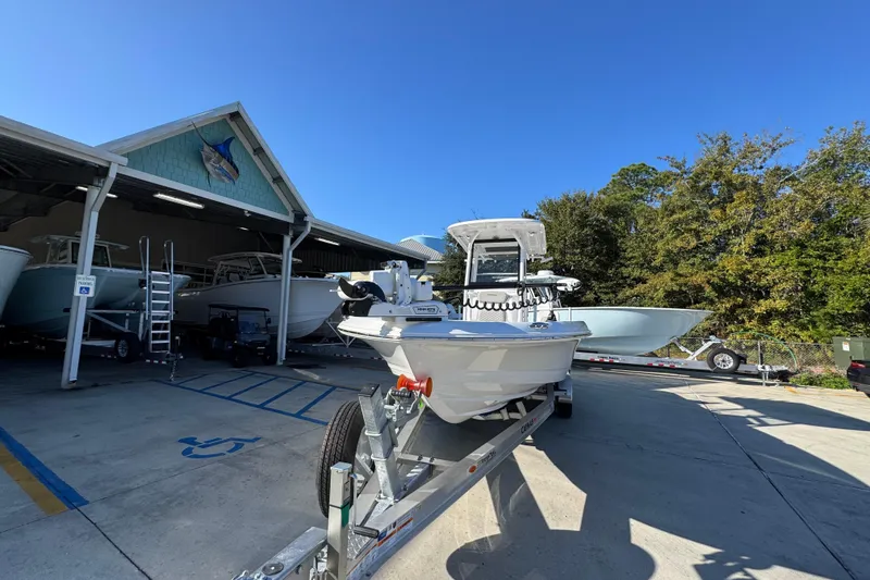 Slide: The Image of 2026 Caymas 26 HB boat on trailer outside a storage facility under clear blue sky. - 5