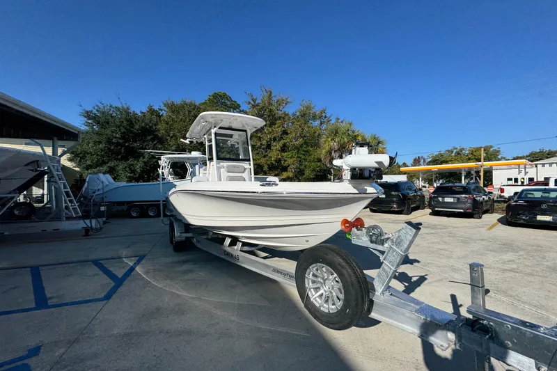Slide: The Image of 2026 Caymas 26 HB boat on trailer in parking lot under clear blue sky. - 7