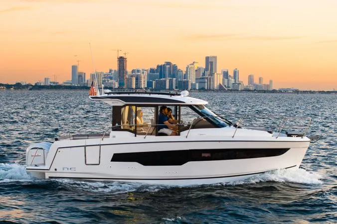 Slide: The Image of Manufacturer Provided Image: 2026 Jeanneau NC 895 Series 2 cruising on water with city skyline at sunset. - 1