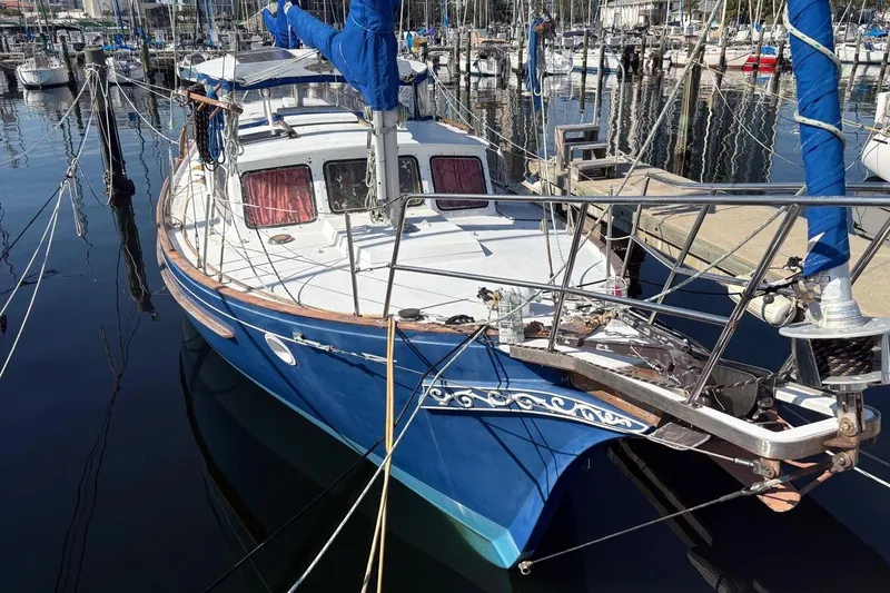 The Image of 1972 Islander 40MS sailboat docked in marina, featuring blue hull and white deck. - 0