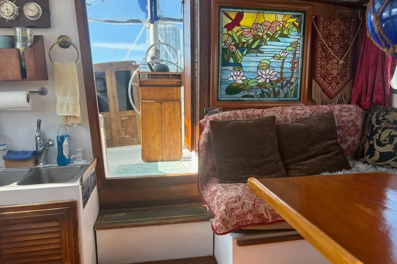 Slide: The Image of Interior of 1972 Islander 40MS sailboat with stained glass and cozy seating area. - 3