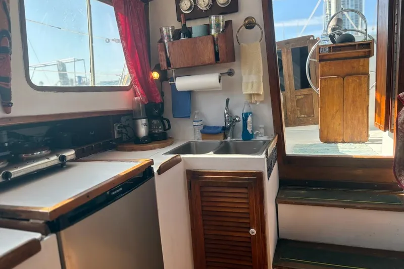 Slide: The Image of Interior of 1972 Islander 40MS sailboat with compact kitchen and wooden accents. - 7