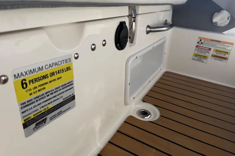 Slide: The Image of 2017 Avon Seasport 420 boat interior, showing capacity label and teak flooring. - 6