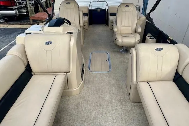 Slide: The Image of 2019 Barletta E22QC pontoon boat interior with beige seating and steering console. - 4