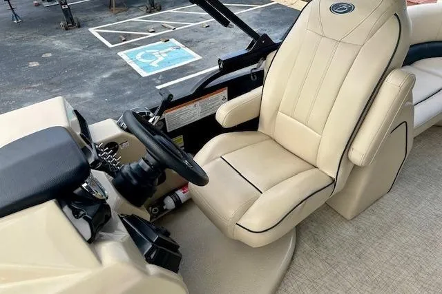 Slide: The Image of Captain's seat of 2019 Barletta E22QC boat with steering wheel and controls. - 7