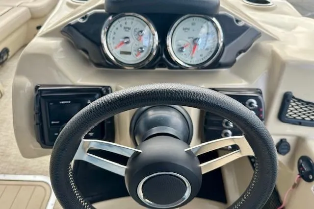 Slide: The Image of Steering wheel and dashboard of 2019 Barletta E22QC boat, featuring gauges and controls. - 9