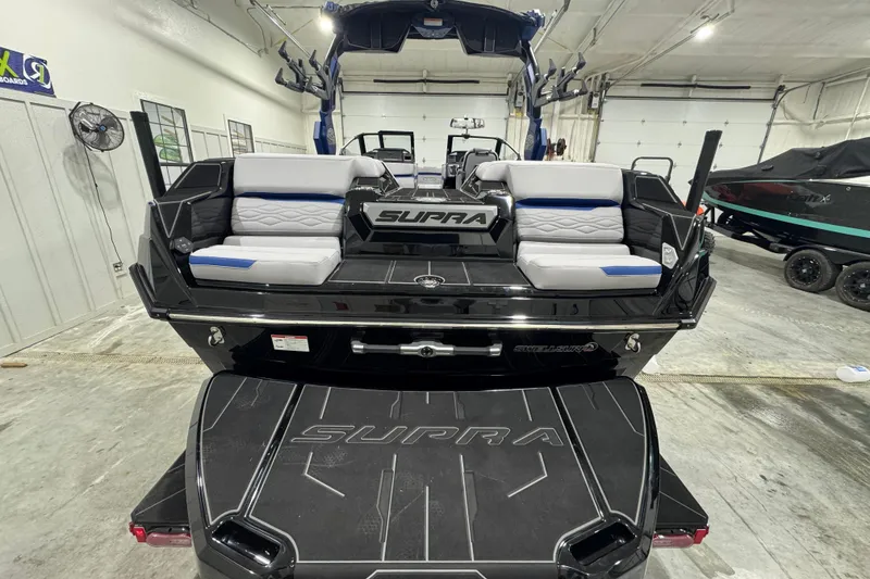 Slide: The Image of 2026 Supra SL 450 boat in showroom, featuring sleek black design and comfortable seating. - 3