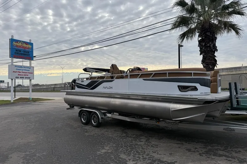 Slide: The Image of 2026 Avalon VENTURE 85 CRUISE pontoon boat on trailer, parked near dealership sign. - 40