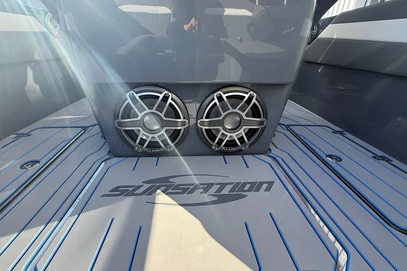 Slide: The Image of 2026 Sunsation 32 CCX boat interior with speakers and logo, sunlit deck. - 22