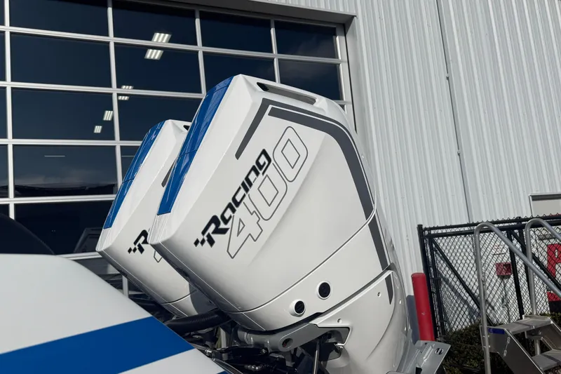 Slide: The Image of 2026 Sunsation 32 CCX with dual Racing 400 outboard engines near a modern building. - 3