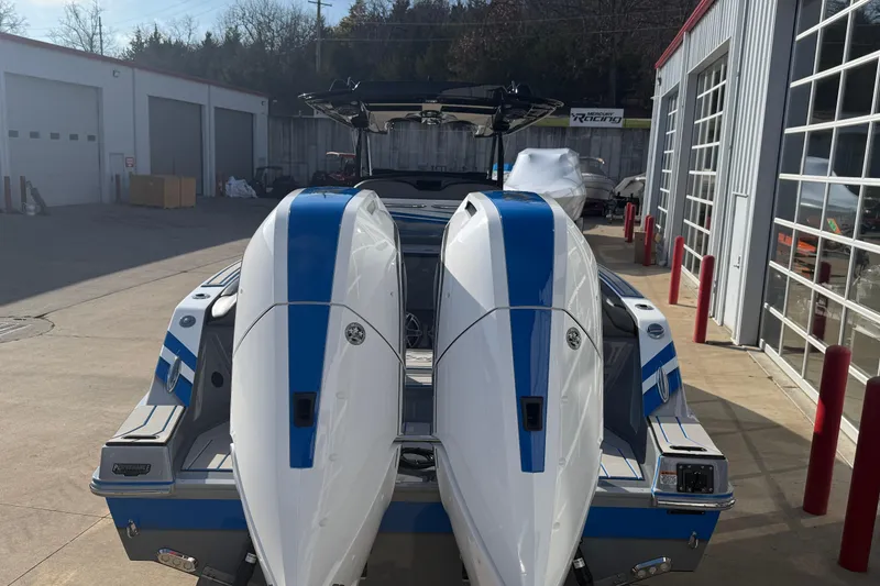 Slide: The Image of 2026 Sunsation 32 CCX boat with dual engines, parked outside a garage. - 4