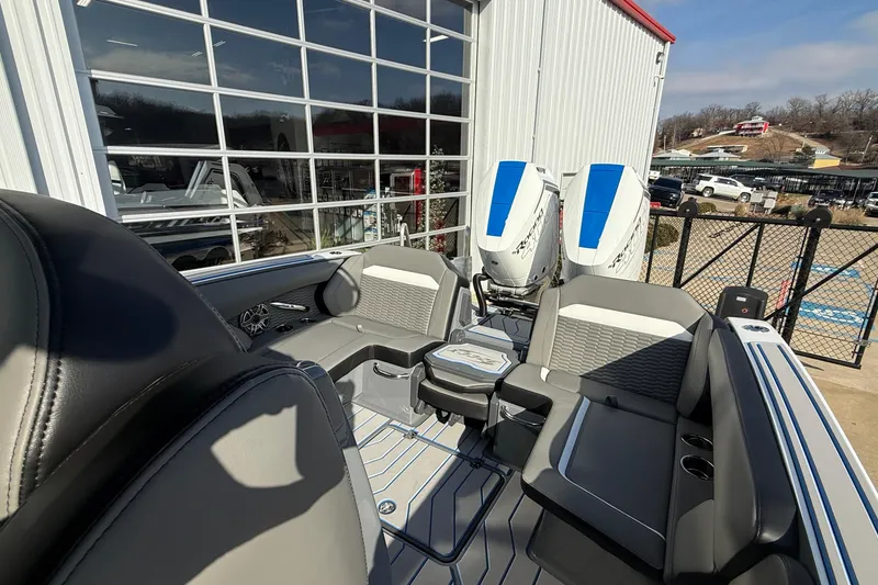 Slide: The Image of 2026 Sunsation 32 CCX boat interior with seating and twin engines, docked near a building. - 6