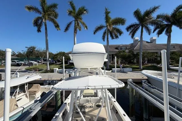 Slide: The Image of 2023 Pathfinder 2600 TRS boat docked with palm trees and building in background. - 16