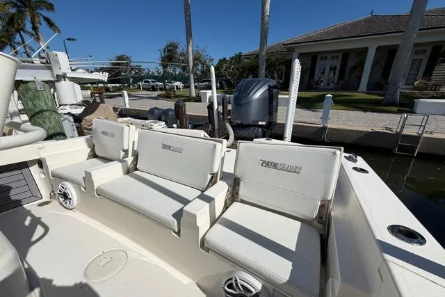 Slide: The Image of 2023 Pathfinder 2600 TRS boat with cushioned seating at a marina. - 19