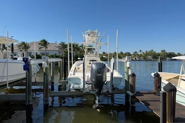 Slide: The Image of 2023 Pathfinder 2600 TRS boat docked at marina with Yamaha outboard motor. - 2