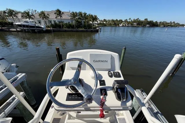 Slide: The Image of 2023 Pathfinder 2600 TRS boat helm with Garmin system, docked by waterfront homes. - 22