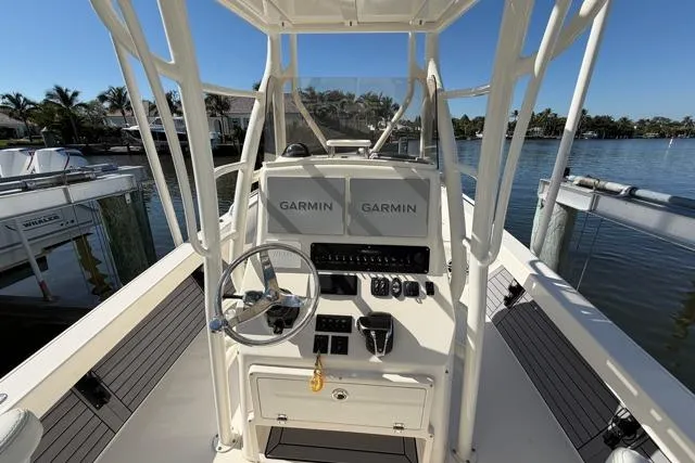 Slide: The Image of 2023 Pathfinder 2600 TRS boat console with Garmin displays, docked by the water. - 5