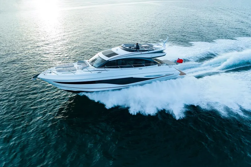 Slide: The Image of 2026 Princess S65 Sportbridge yacht cruising on open sea under clear blue sky. - 2