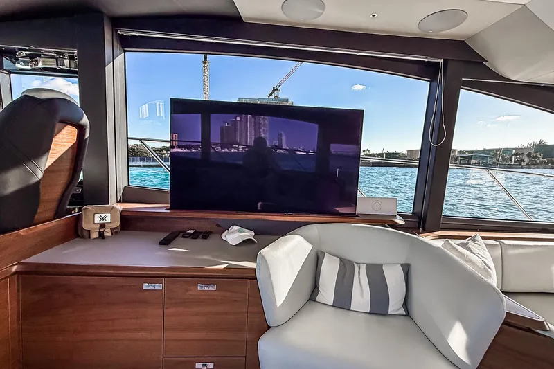 Slide: The Image of Luxurious interior of 2026 Princess S65 Sportbridge yacht with modern seating and scenic window view. - 49