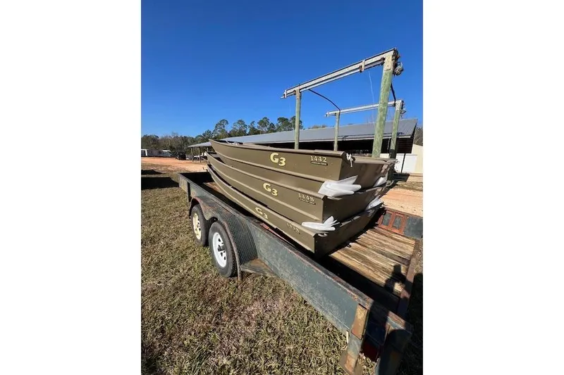 The Image of Trailer carrying stacked G3 boats, model 1442, year 2026, under clear blue sky. - 1