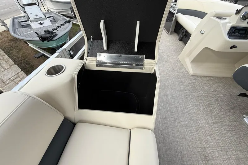 Slide: The Image of 2026 Avalon VLS Quad Lounge boat interior with open storage compartment and cup holder. - 14