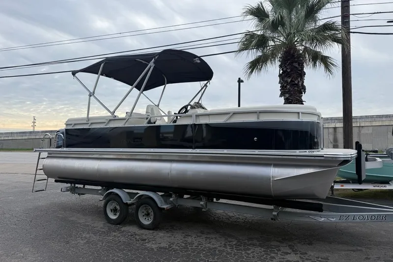 Slide: The Image of 2026 Avalon VLS Quad Lounge pontoon boat on trailer. - 27