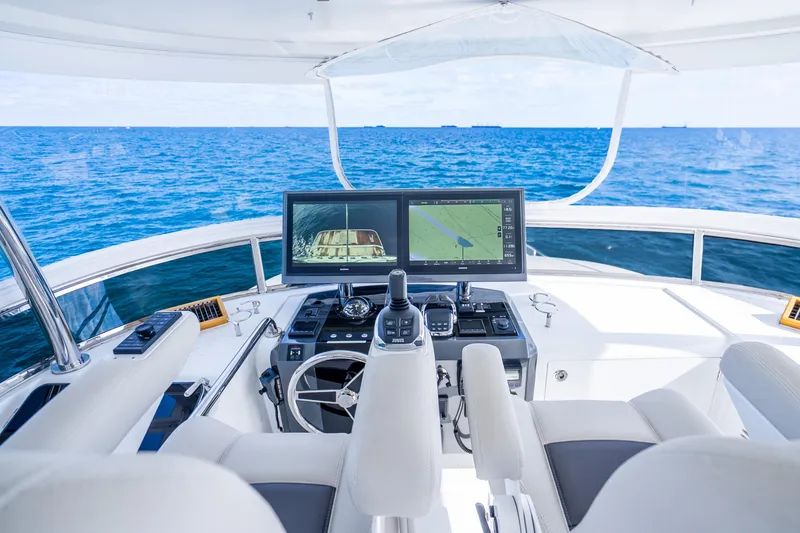 Slide: The Image of Cockpit view of 2021 Ocean Alexander 70E Motoryacht with navigation screens and ocean backdrop. - 21