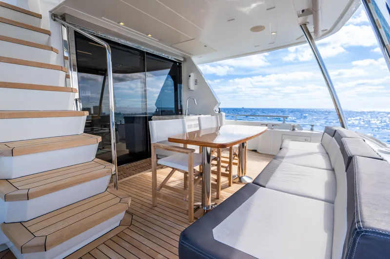 Slide: The Image of Luxurious 2021 Ocean Alexander 70E Motoryacht deck with seating, table, and ocean view. - 24