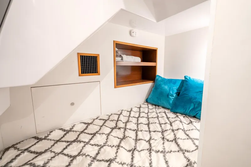 Slide: The Image of Cozy cabin interior of 2021 Ocean Alexander 70E Motoryacht with blue pillows and shelving. - 58