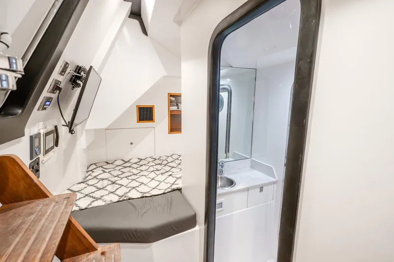 Slide: The Image of 2021 Ocean Alexander 70E Motoryacht cabin with bed, TV, and compact bathroom. - 59