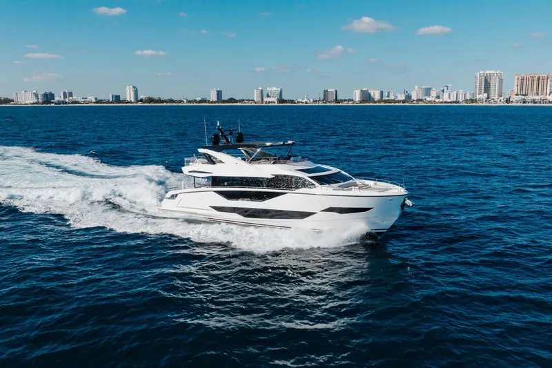 The Image of 2023 Sunseeker 90 Ocean yacht cruising on blue ocean near city skyline. - 0