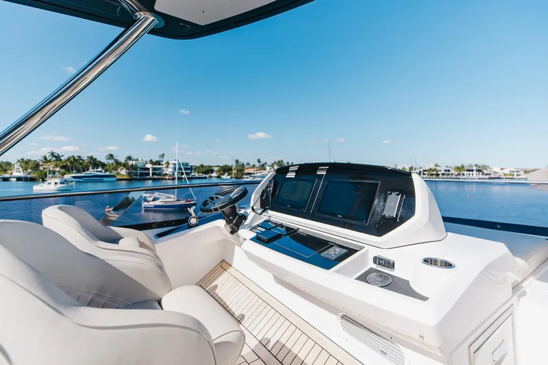Slide: The Image of 2023 Sunseeker 90 Ocean yacht helm with modern controls and scenic marina view. - 45