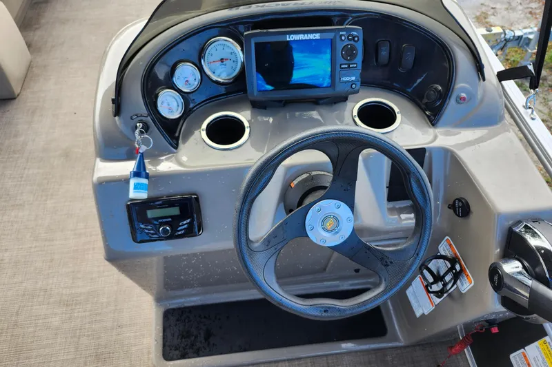 Slide: The Image of 2023 Sun Tracker Party Barge 18 DLX dashboard with steering wheel and navigation system. - 12