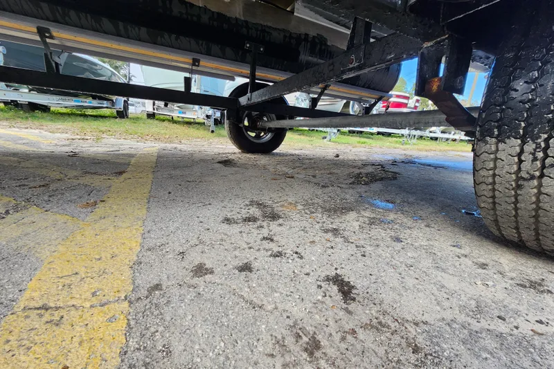 Slide: The Image of Underneath view of a 2023 Sun Tracker Party Barge 18 DLX trailer on pavement. - 17