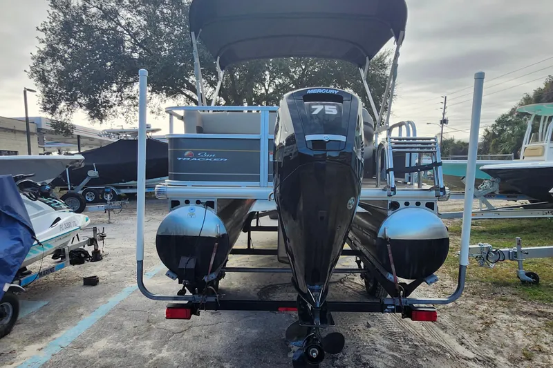 Slide: The Image of 2023 Sun Tracker Party Barge 18 DLX pontoon boat with Mercury 75 engine, parked outdoors. - 4