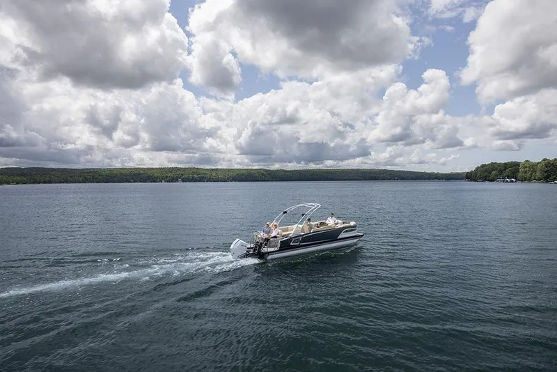 Slide: The Image of 2026 Avalon Excalibur LTD Quad Lounger Shift pontoon boat on trailer at dealership. - 9
