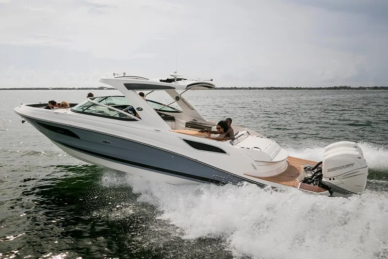 Slide: The Image of 2018 Sea Ray SLX 350 Outboard cruising on open water under cloudy skies. - 2