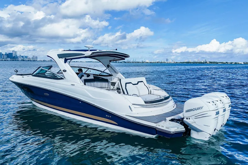 Slide: The Image of 2018 Sea Ray SLX 350 Outboard cruising on a sunny day with city skyline backdrop. - 7