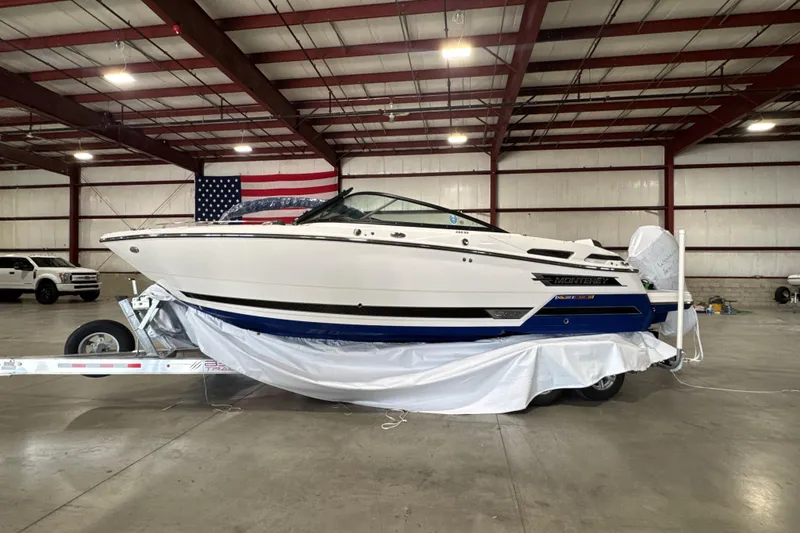 Slide: The Image of 2023 Monterey 255SS Super Sport boat in warehouse, side view with American flag. - 27