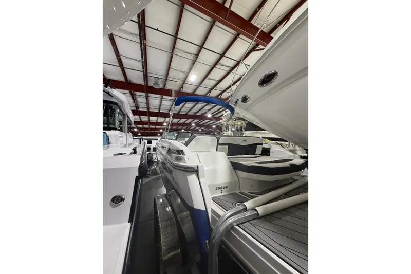 Slide: The Image of 2023 Monterey 255SS Super Sport boat in indoor showroom, showcasing sleek design. - 5