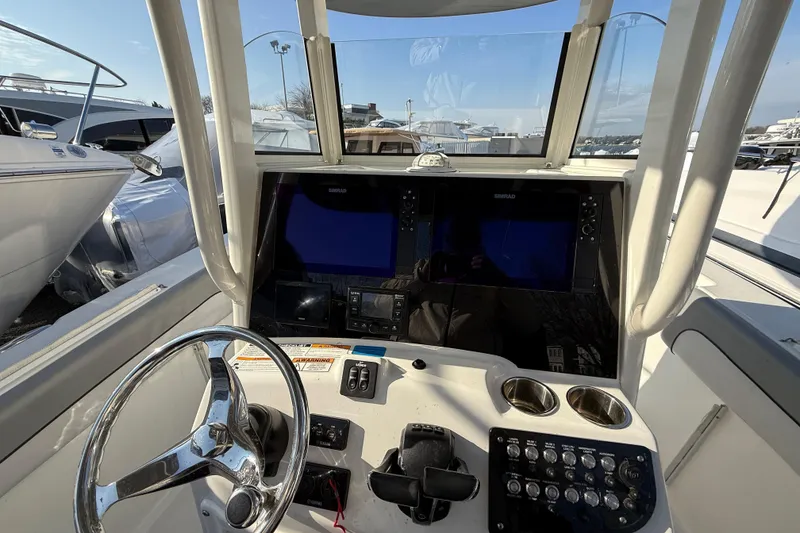 Slide: The Image of 2021 NauticStar 28 XS boat dashboard with steering wheel and navigation screens. - 10